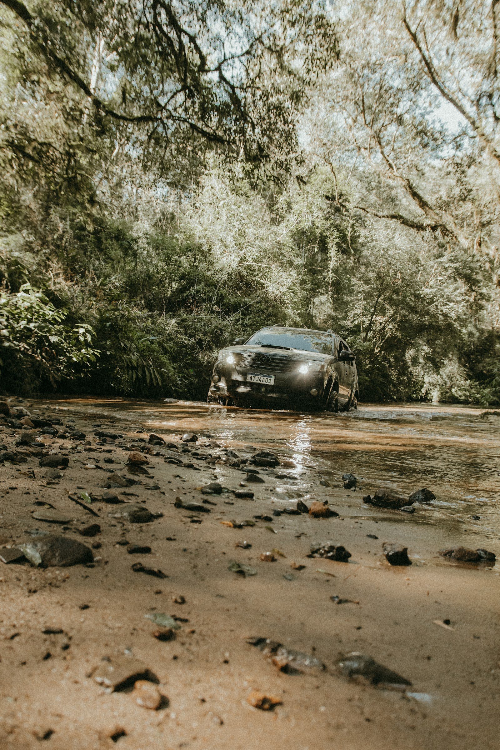 Veículo cruzando um trecho de rio na floresta